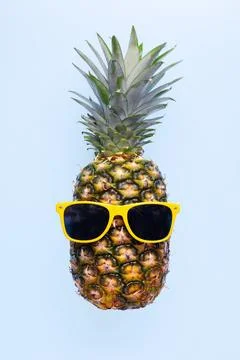 Pineapple with sunglasses on blue background Stock Photos