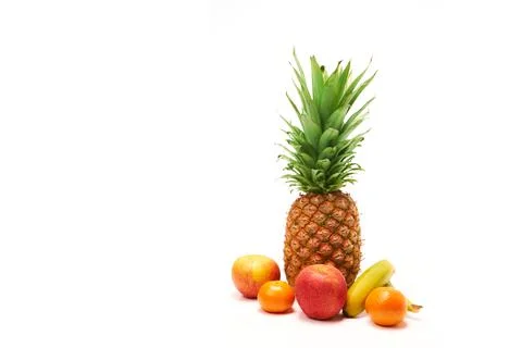 Pineapple surrounded by fruit with white background and copy space Stock Photos