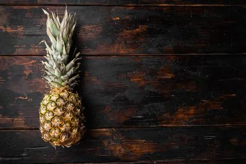 Pineapple tropical fruit, on old dark wooden table background, top view flat  Stock Photos
