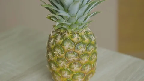 Pineapple on a wooden table. Slow Motion Camera Stock Footage 128654078