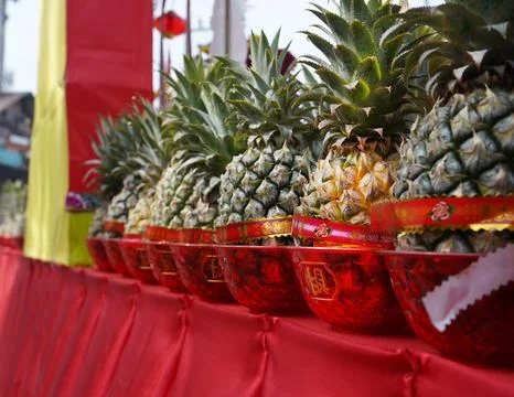 Pineapples in red cups stand Stock Photos