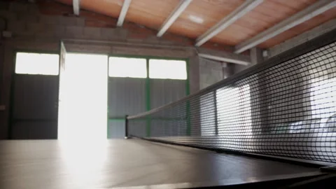 Ping Pong Ball Bouncing on Table Tennis Table in Sunlit Garage Interior Stock Footage 336482226