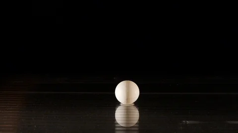 Ping pong ball getting flamed in slow motion on black background Stock Footage 88809348
