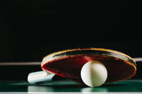 Ping pong racket leaning on ping pong ball Stock Photos