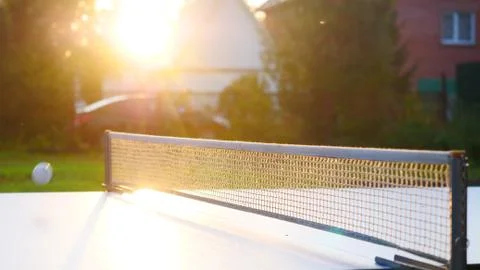 Ping pong table and net closeup in sunset light. Shadow Stock Photos