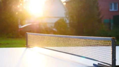 Ping pong table and net closeup in sunset light. Shadow Stock Photos