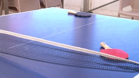 Ping pong table with net and two paddles, ready for a game, Table tennis setup Stock Footage 329650629
