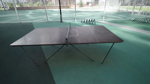 Ping pong table waits for players on shady sports ground Stock Footage 330284337