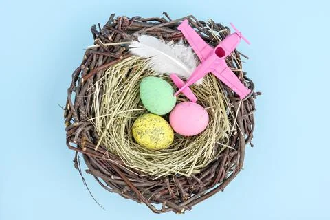 Pink airplane and easter egg nest flatlay Stock Photos