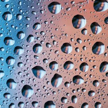 Pink and blue background with drops on the glass. Macro shot. Stock Photos