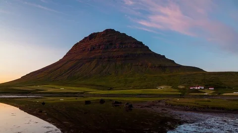 Pink and blue clouds rolling over pyramid shaped mountain Kirkjufell at sunset Stock Footage 73011315