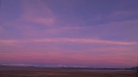 Pink and Blue Sunset with Sprawling Fields and Snow Covered Mountains 스톡 동영상 124595052