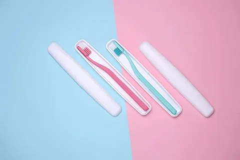 Pink and blue toothbrushes with toothpaste on pastel background Fotos de archivo