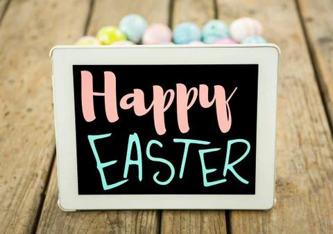 Pink and blue type on tablet on wood table with easter eggs Stock Fotos