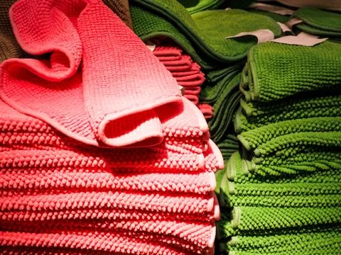Pink and green Stack of bath towels on light in store closeup Stock Photos