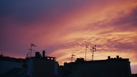 Pink and orange clouds moving above parisian rooftops at sunset Stock Footage 346990282