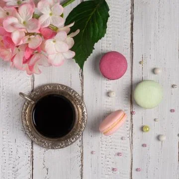 Pink and purple macarons on a withe background. Cup of tea coffee. Stock Photos