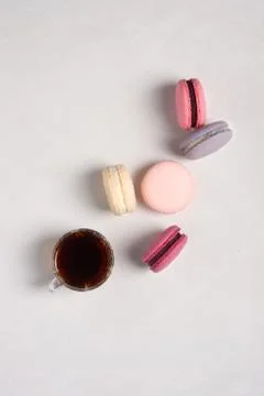 Pink and purple macarons on a withe background. Cup of tea coffee. Stock Photos