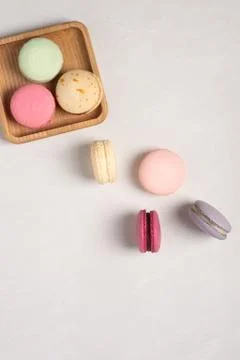 Pink and purple macarons on a withe background. Wooden plate. Macaroons close up Photos