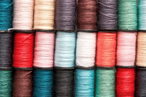 Pink and turquoise colored thread reels pattern texture Foto stock