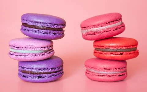 Pink and Violet macaroons in a stack on a fashionable coral background close- Stock Photos