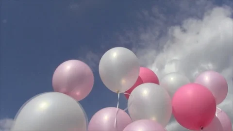 Pink and white balloons on threads shaking wind against of the sky and clouds Stock Footage 80595950