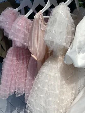 Pink and white dresses with sequins creating a delicate and textured backgrou Stock Photos
