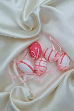 Pink and white easter eggs on a shiny textile background Stock Photos