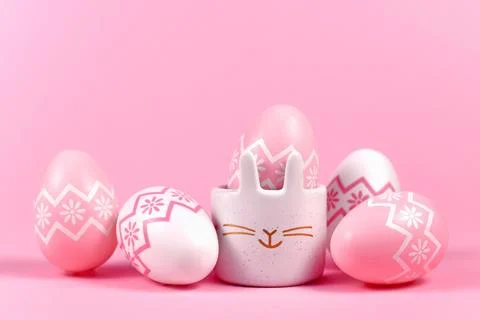 Pink and white painted easter eggs and cute easter egg cup in shape of bunny on Stock Photos