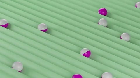 Pink and white spheres rolling on green grooved surface Stock Footage 324490467