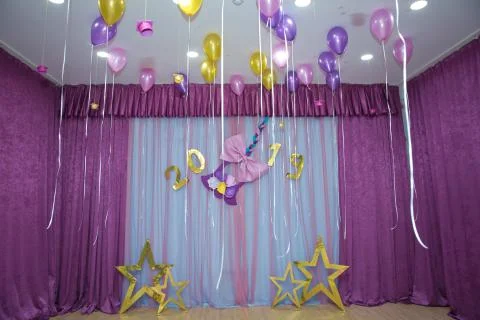 Pink and yellow balloons float on the white ceiling in the room for the party Stock Photos