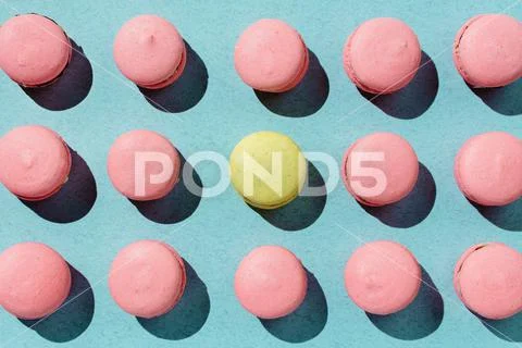Pink and yellow vegan macaroons arranged on pastel blue background Stock Photos