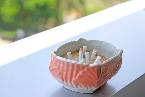 The pink ashtray is placed on the table. Stock Photos