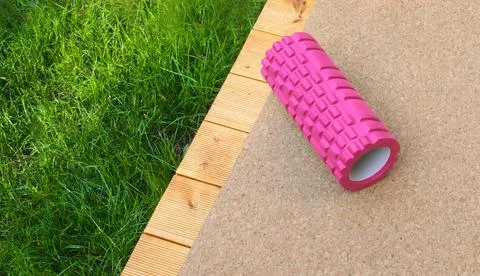 Pink back massage roller. Back problems concept. Home rehabilitation. Foto stock