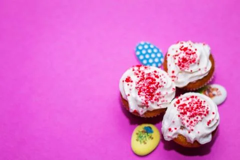On a pink background close-up of colored Easter eggs and cupcake, holiday Stock Photos