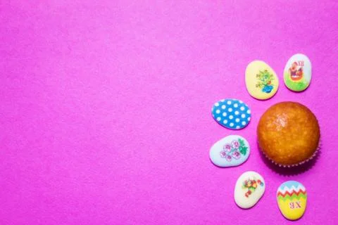 On a pink background close-up of colored Easter eggs and cupcake, holiday Stock Photos