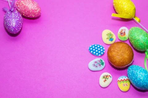 On a pink background close-up of colored Easter eggs and cupcake, holiday Stock Photos