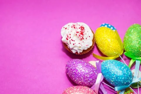 On a pink background close-up of colored Easter eggs and cupcake, holiday Stock Photos