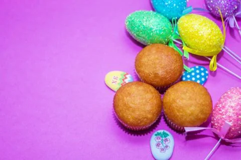 On a pink background close-up of colored Easter eggs and cupcake, holiday Stock Photos