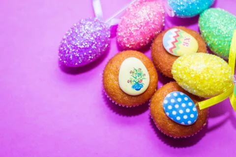 On a pink background close-up of colored Easter eggs and cupcake, holiday Stock Photos