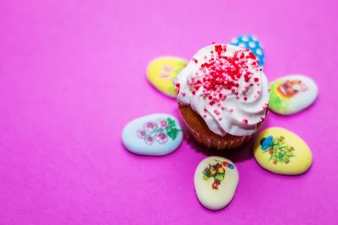On a pink background close-up of colored Easter eggs and cupcake, holiday bac Stock Photos