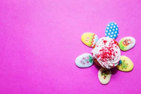 On a pink background close-up of colored Easter eggs and cupcake, holiday bac Stock Photos