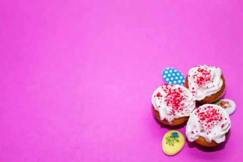 On a pink background close-up of colored Easter eggs and cupcake, holiday bac Stock Photos
