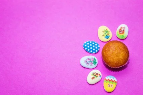 On a pink background close-up of colored Easter eggs and cupcake, holiday bac Stock Photos