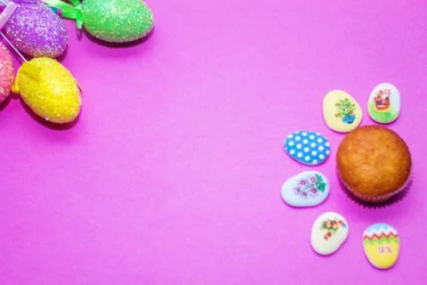 On a pink background close-up of colored Easter eggs and cupcake, holiday bac Stock Photos