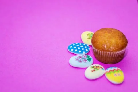 On a pink background close-up of colored Easter eggs and cupcake, holiday bac Stock Photos