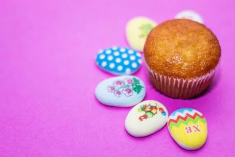 On a pink background close-up of colored Easter eggs and cupcake, holiday bac Stock Photos