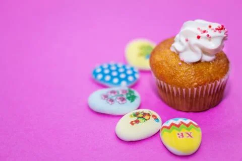 On a pink background close-up of colored Easter eggs and cupcake, holiday bac Stock Photos