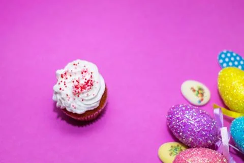 On a pink background close-up of colored Easter eggs and cupcake, holiday bac Stock Photos