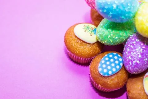 On a pink background close-up of colored Easter eggs and cupcake, holiday bac Stock Photos